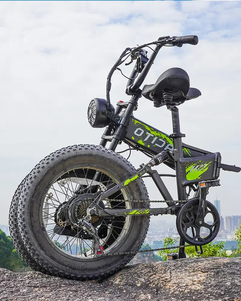 Black - OTIDA R7 MAX Dual Motor Electric Bike with green accents on a rocky surface with a cityscape in the background