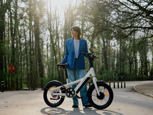 Person holding a white Heybike EC Compact City Electric Bike in a park setting
