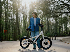 Person holding a white Heybike EC Compact City Electric Bike in a park setting