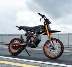 Riding Times GT54 Electric Bike on a road with a cloudy sky.